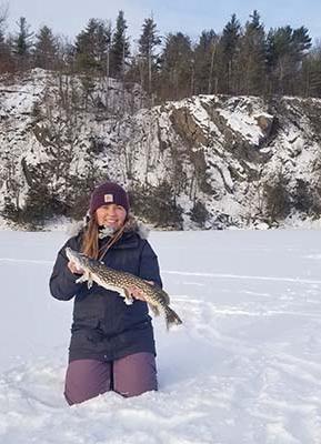 Katlyn barhite holding a fish in the snow